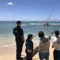 The Coast Guard, State of Hawaii, and salvors are working to remove the sailing vessel, Steady Beat, aground near Waikiki Reef Hotel, March 22, 2020. The owner’s insurance company has hired a salvage team to remove the 35-foot, double masted vessel. (U.S. Coast Guard photo by Russ Strathern) 