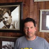 ohn Hemingway poses next to photo of grandfather Ernest Hemingway at the Bimini Big Game Club Resort.