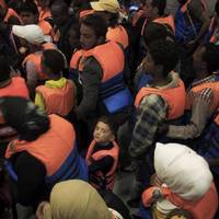  A young boy surrounded by adults after being rescued in June 2014 from a boat on the Mediterranean Sea. Photo: UNHCR/A. D’Amato