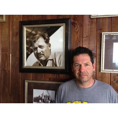 ohn Hemingway poses next to photo of grandfather Ernest Hemingway at the Bimini Big Game Club Resort.