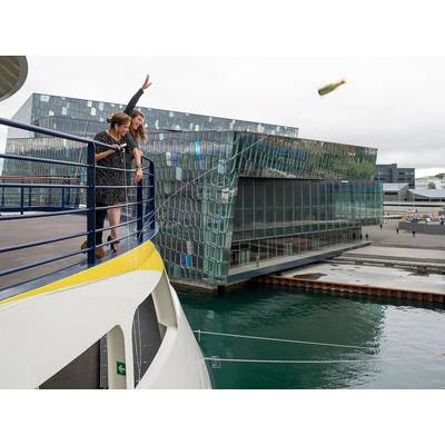 Jen Martin, Director of Field Staff & Expedition Development, and Ana Esteves, Director, Hotel Operations, toss the champagne bottle at the christening of National Geographic Endurance in Reykjavik, Iceland. 
Photo credit: Michael S. Nolan